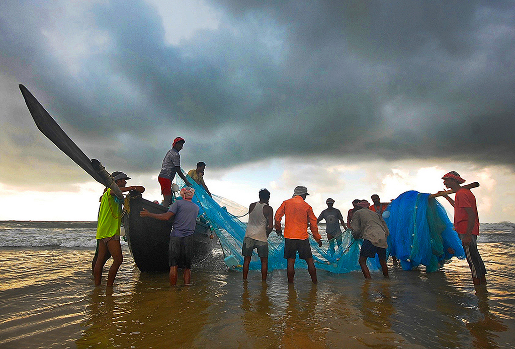 a group of people pulling a fishing net out of the water